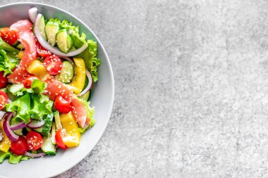 Somon, avokado, domates ve salatalıklı sağlıklı salata.