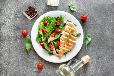 Beyaz tabakta sebzeli ızgara tavuk göğsü.