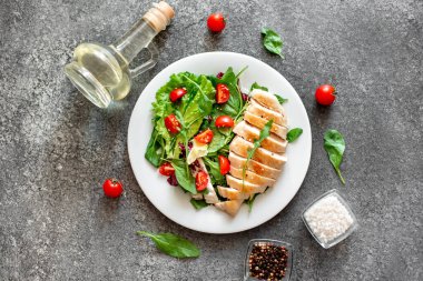 Beyaz tabakta sebzeli ızgara tavuk göğsü.