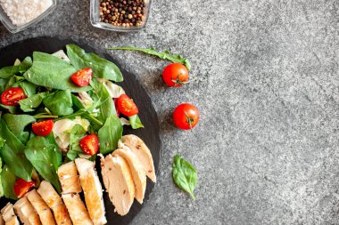 Beyaz tabakta sebzeli ızgara tavuk göğsü.