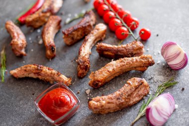 Baharatlı ızgara domuz pirzolası ve gri arka planda otlar.