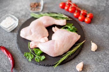 Tahta üzerinde baharat ve otlarla çiğ tavuk bacağı