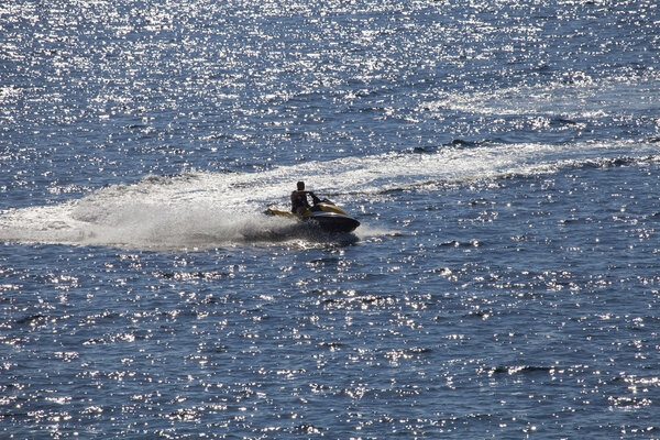 Man on Wave Runner in sparkling sea.