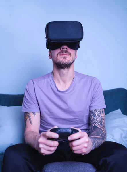 Man wearing smartphone vr glasses while playing computer game at home. Vertical