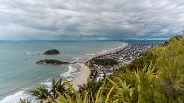 Bulutlu bir yaz gününde Maunganui Dağı plajında gözcülük. Tauranga, Yeni Zelanda