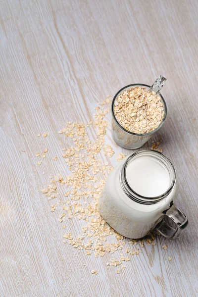 Glass of oat milk and oat grains. Vegan and non dairy concept. Top view. Vertical photography