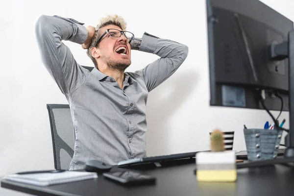 Businessman stressed out and screaming at the office. Stress at work concept. White background