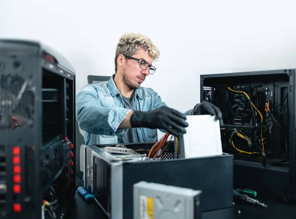 Man with eyeglasses doing pc maintenance on desktop computer. White background