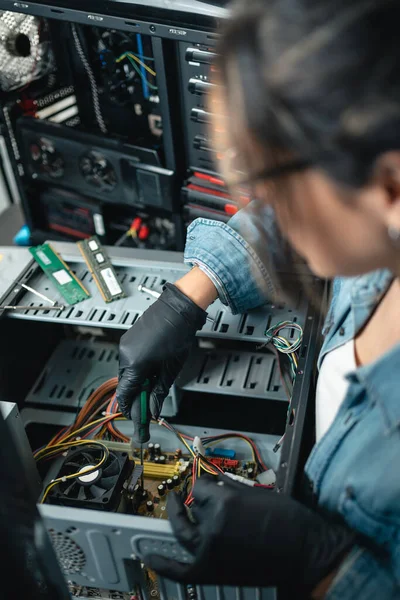 Female computer repair service working on pc cabinet. Close up. Vertical photo