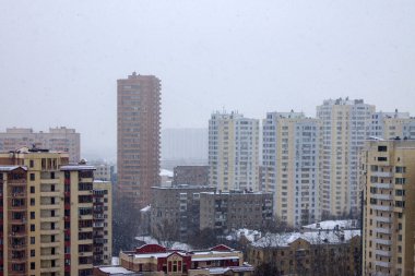 Şehir caddesinin panoramik manzarası modern çok katlı binalar ve bulutlu bir kış gününde karla kaplı çatılar ve kopyalamak için yer. Kavram - şehir manzarası