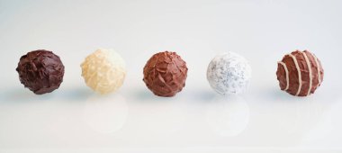 Beyaz arka planda beş sıra çikolatalı trüf.