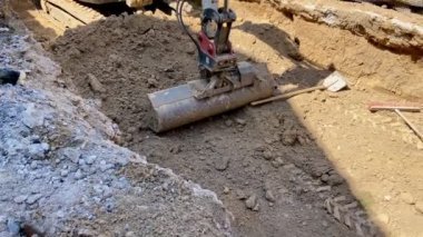 Kazıcı yerdeki bir deliğe kürek çekiyor.
