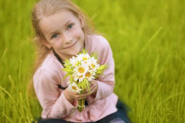 küçük sarışın kız gülümseyerek