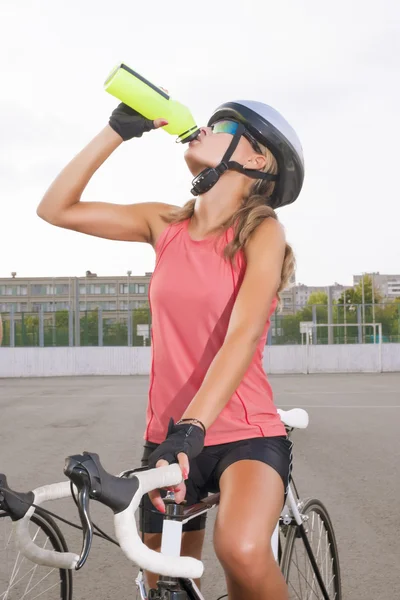 Cyclist woman takes a water break