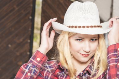 Stetson giyen güzel şehvetli gülümseyen mutlu sarışın cowgirl