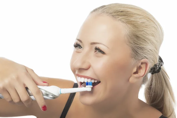 diş sağlığı: Beyaz sarışın bir kadın kullanarak dişleri fırçalama