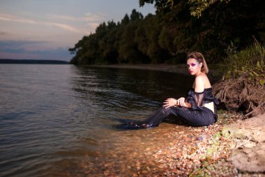 Deniz Kızı Sahildeki Kayaların Üzerinde Pozisyon Verirken Yüzünde Sanatsal Makyaj ve Yüzünde Siyah Parlak Kuyruk Renkli Spangles Posing Denizlerin Kraliçesi Görüntüsüyle