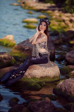 Deniz Kızları Deniz Kıyısında Kayalıklarda Deniz Kabuğu Madalyalı Taç Giyiyor ve Siyah Parlak Kuyruklu Deniz Kraliçesi Gibi Korunuyor. Dikey Bileşim