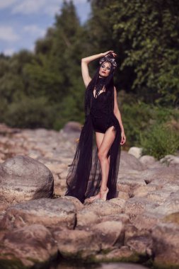 Siyah Işık Elbiseli Genç Seksi Beyaz Dansçı. Rocky Seashore 'da Dans Ederken Üzerinde Denizkabuğu Taç Giyiyor. Dikey Çekim