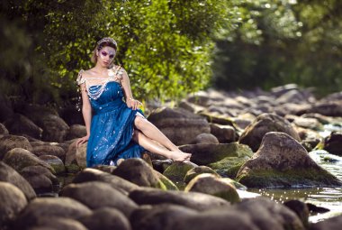 Rahat Bayan Deniz Kızı pozu, Artistik Mavi Elbise ve Islak Elbise Giyen Askılar, Rocky Shore Açık Hava. Yatay Resim