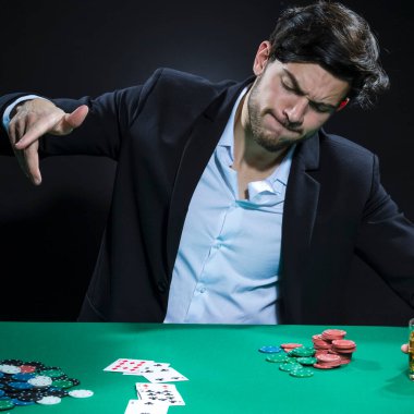 Oyun oynarken Pocker Masasında Fiş ve Kartlarla Duygusal Yakışıklı Esmer Brunet Poker Oyuncusu. Kare Resim