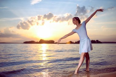 Beyaz elbiseli Japon Bale Dansçısı ve Okyanus Dalgalarında Gümüş Taç Pozisyonu Denizde Dans Eden Dans Elleri ile Bale Pasını Gösterirken. Yatay Resim Kompozisyonu