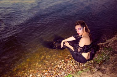 Deniz Kızı Sahildeki Kayaların Üzerinde Pozisyon Verirken Yüzünde Sanatsal Makyaj ve Yüzünde Siyah Parlak Kuyruk Renkli Spangles Posing Denizlerin Kraliçesi. Yatay Vuruş