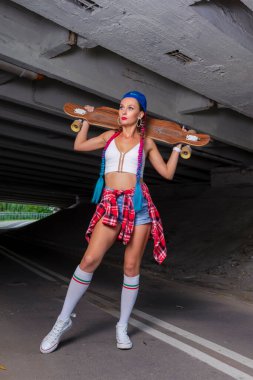 Grunge Çevre ve Giyinme Şapkası ve Güneş Gözlüğü 'nde Uzun Tahtalı Kadın Hippi Kaykaycı Poz Veriyor. Dikey Resim Yönlendirmesi