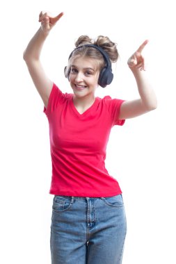 Hoş Dans Eden Sarışın Kız, Kulaklıkla Günlük Giysiler Giyiyor, Eller Kaldırılmış ve Beyazın Üzerinde Dans Ediyor. Dikey resim