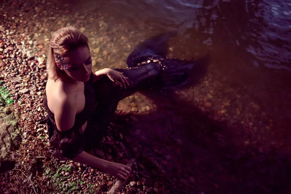 Karanlık Deniz Kızı Kayalıklar Üzerinde Sahilde Pozlar Verirken Sanatsal Makyaj ve Yüzü Sarkık ve Siyah Parlak Kuyruklu Üzerinde Renkli Spangles 'ın Deniz Kraliçesi Rolüyle.