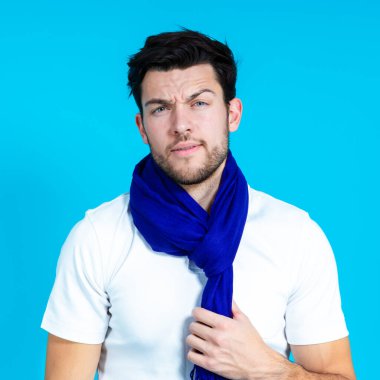 Mavi, uzun, buruşuk suratlı, mavi arkaplanlı, sakin, beyaz, esmer bir adam. Kare Resim