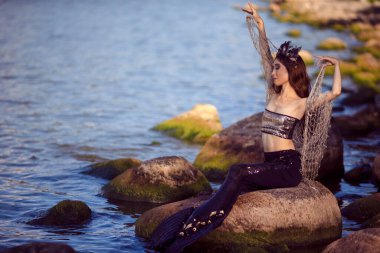 Deniz kabuğu desenli taçla süslenmiş deniz kabuğu ve denizin kraliçesi sıcacık gövdesiyle kaplı siyah parlak kuyruk takan Asyalı Deniz Kızı. Yatay Yönlendirme