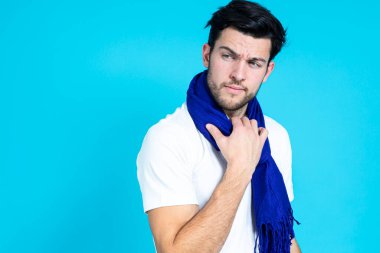 Beyaz gömlekli ve mavi arkaplanlı, koyu mavi eşarplı yakışıklı adam pozu. Yatay görüntü.