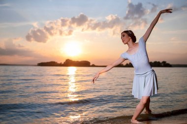Beyaz elbiseli Japon Bale Dansçısı ve Okyanus Dalgalarında Gümüş Taç Pozisyonu Denizde Dans Eden Dans Elleri ile Bale Pasını Gösterirken. Yatay Resim