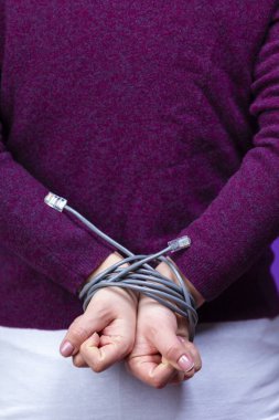 Mor Kazaklı Kadın, Elleri Bilgisayar Ağı Kablosu Arkasında Bağlı Mor Arkaplan Karşısında Devam Ediyor. Dikey Resim