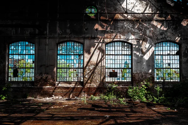 Foto de um interior industrial abandonado com luz brilhante — Fotografia de Stock