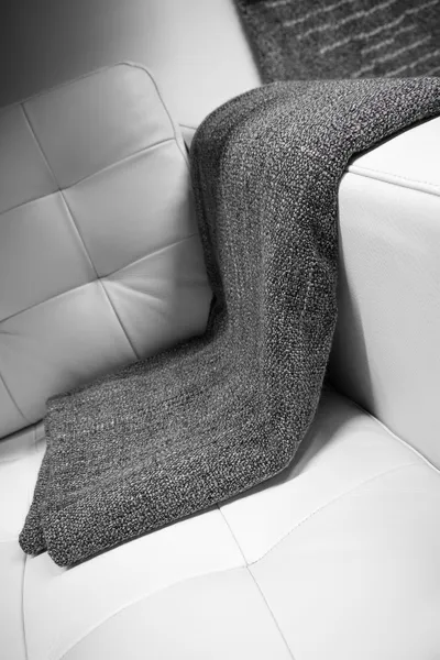 Graue Decke über einer Ledercouch drapiert — Stockfoto