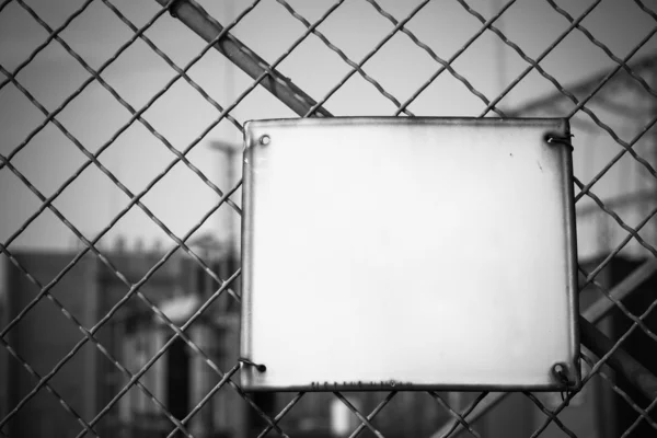 Leere weiße Metalltafel am Zaun — Stockfoto