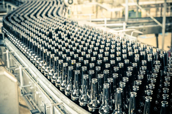 Botellas de cerveza en la cinta transportadora — Foto de Stock