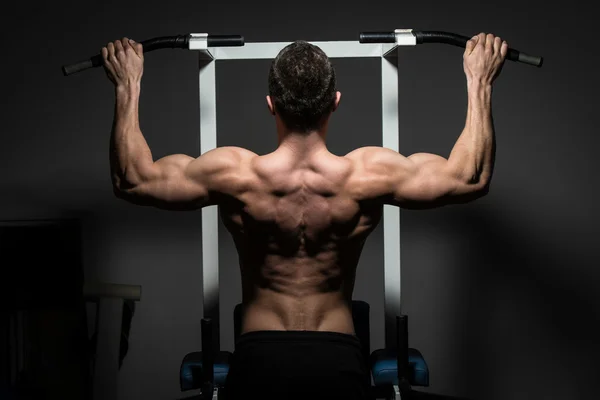 Young male bodybuilder doing heavy weight exercise — Stock Photo, Image