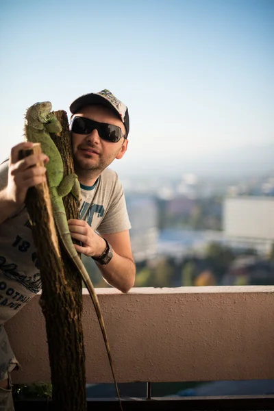 Porträtt av den unge mannen med iguana — Stockfoto