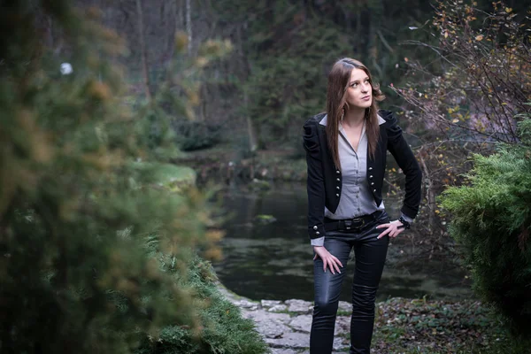 若い女性のジャケットに立っていると湖でポーズ — ストック写真
