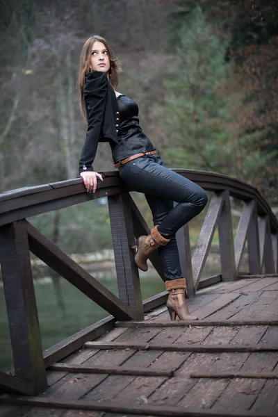 Молодая женщина склоняется на мосту — стоковое фото