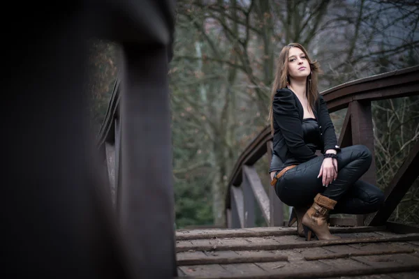 Fiatal nő crouch hídnál — Stock Fotó