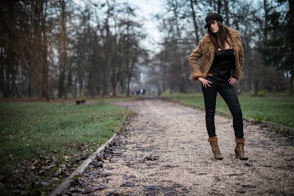 Молодая женщина в пиджаке стоит и позирует в лесу — стоковое фото