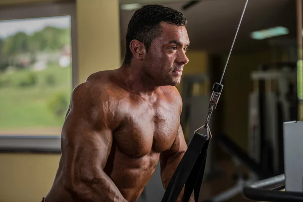 Muskulöser Bodybuilder beim Krafttraining für Trizeps mit Seil — Stockfoto