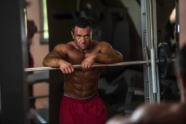 Bodybuilder resting after doing heavy weight exercise — Stock Photo, Image