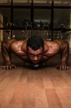 Male bodybuilder doing push ups at the floor