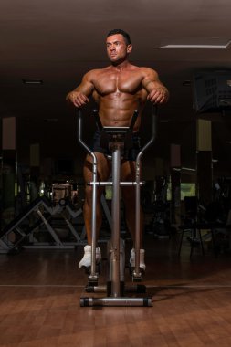 erkek vücut geliştirmeci eliptik makinesi kullanma