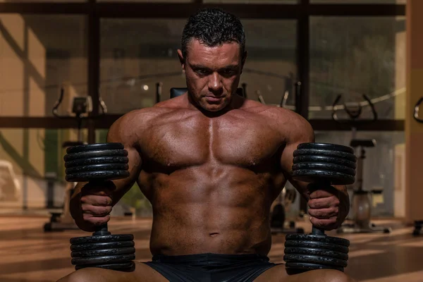 Male bodybuilder resting after doing heavy weight exercise — Stock Photo, Image